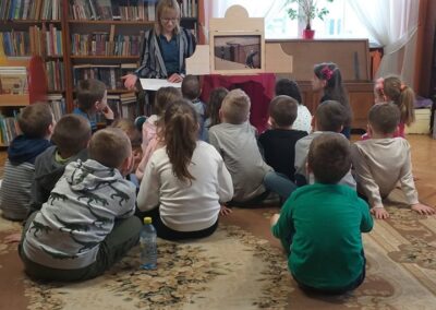 Uczniowie słuchają opowieści w bibliotece