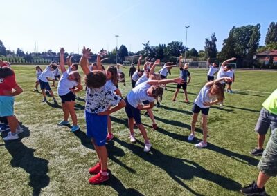 uczniowie rozciągający się na boisku sportowym