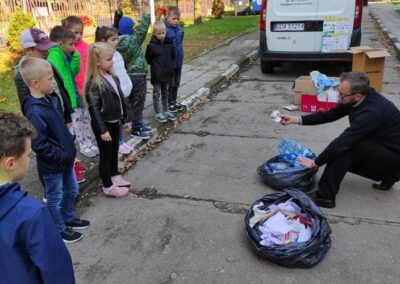 uczniowie patrzą, jak się segreguje śmieci