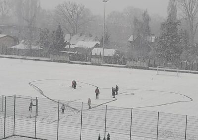 uczniowie na boisku szkolnym pokrytym śniegiem